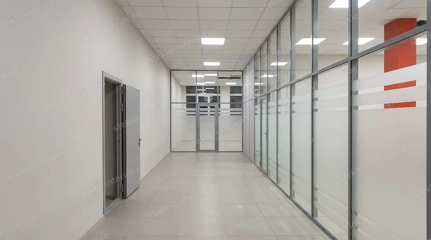 Проход вдоль стеклянных перегородок, в торце — стеклянная стена с дверью и полосами плёнки, офис в Воскресенске
